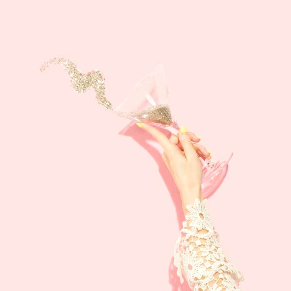 Champagne giclant d'une coupe tenue par une main