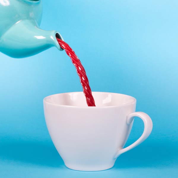 Thé coulant depuis une théière dans une tasse